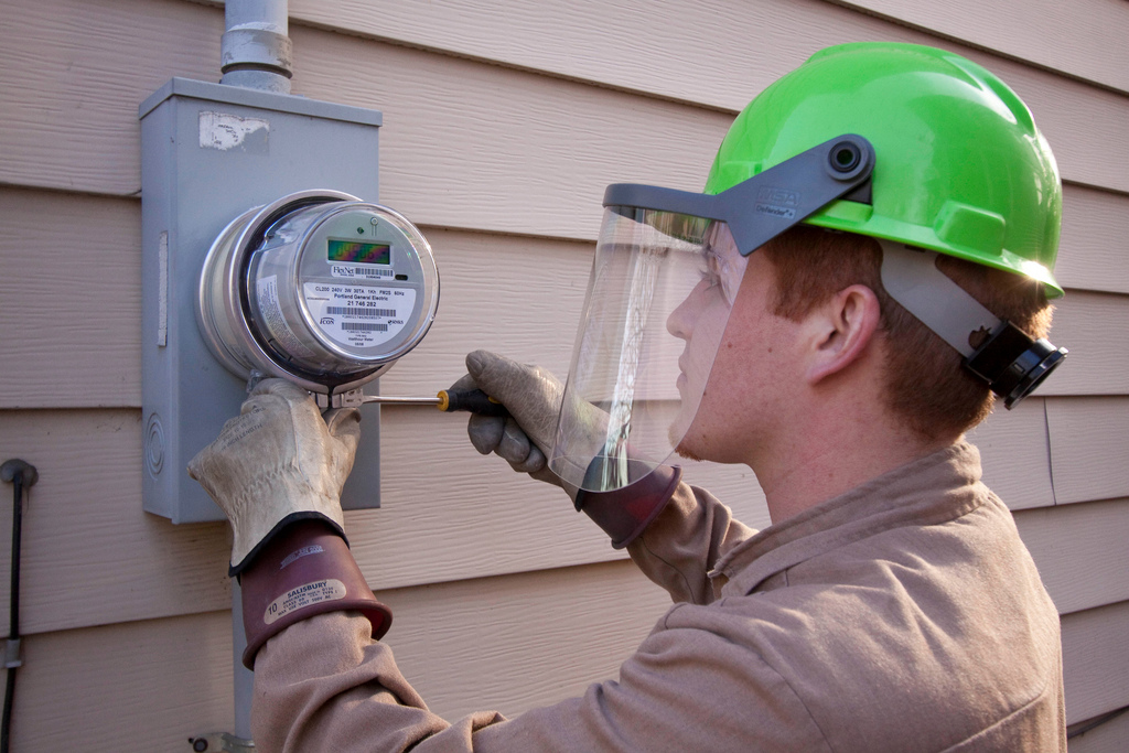 David Graft of Wellington Energy Inc, works to install a new watthour meter at a residence in Portland, OR.